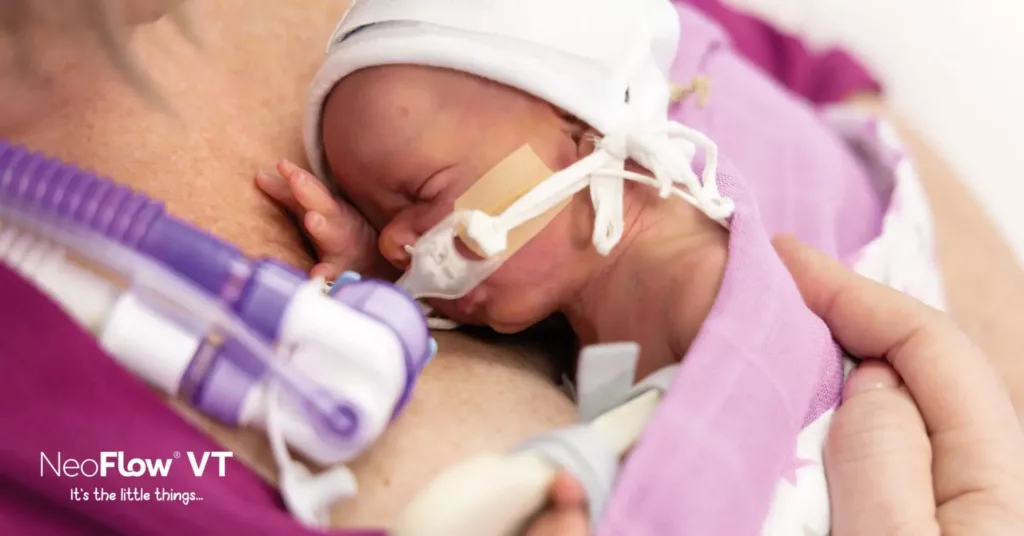 Image of a baby being cuddled skin to skin connected to an Armstrong Medical NeoFlow device